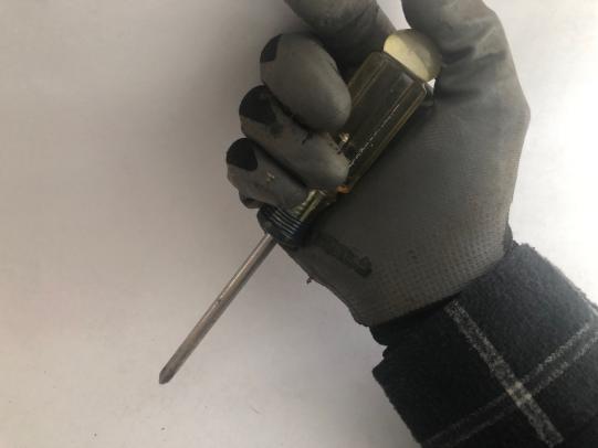 Gloved hand holding screwdriver