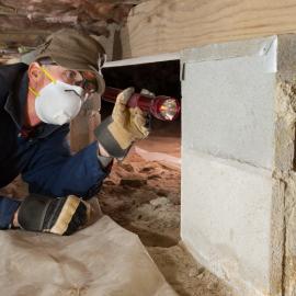 Worker performing inspection in crawl space