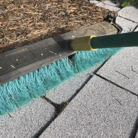 Broom sweeping debris on roof