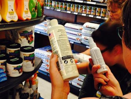 Group in store aisle reading pesticide product labels