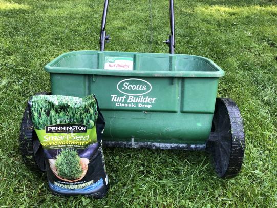Seed spreader and bag of seeds on lawn