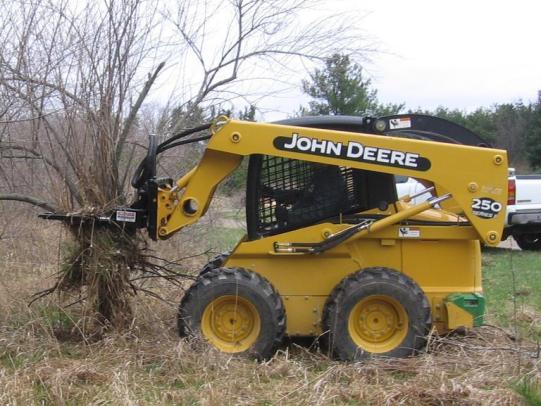 Tractor removing invasive shrub