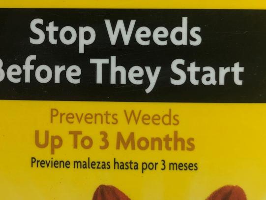 Text on the label states “Stop Weeds Before They Start”