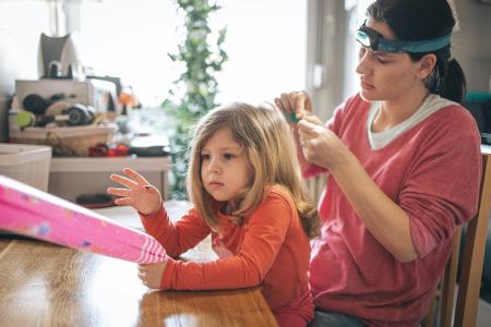 Adult checking child’s hair for lice